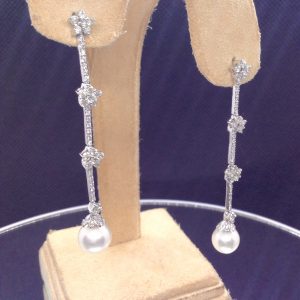 Two 18k White Gold Long Drop 1.50 Ct Diamond Earrings with 8mm South Sea Pearl Drops hanging on fake ears