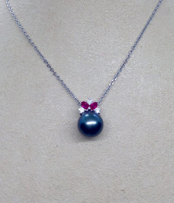 A woman wearing a 11mm Tahitian Pearl with 0.12 Ct Diamond and 0.20Ct Ruby 14k White Gold Pendant
