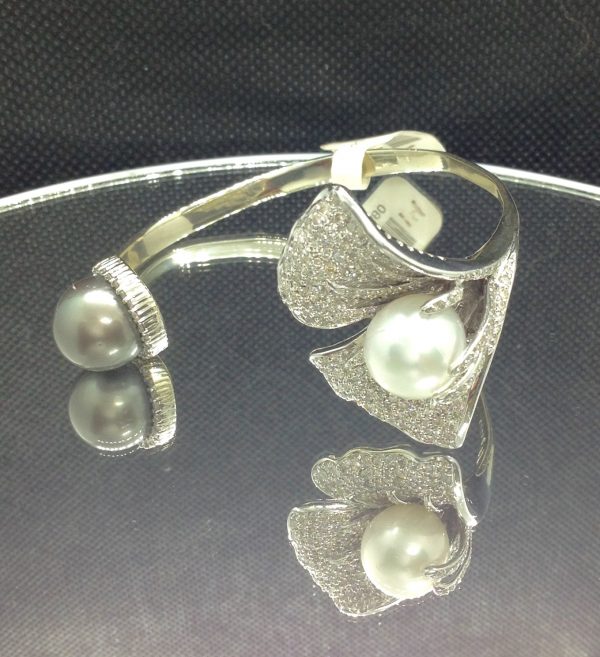 Ying-Yang 14k White Gold Bangle 13mm South Sea Pearl and 13mm Tahitian Pearl with 2.25 Ct Diamond on a piece of glass