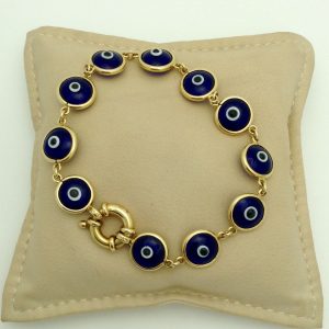 Good Luck 18K Yellow Gold Evil Eye Bracelet Mariner Clasp on a pillow