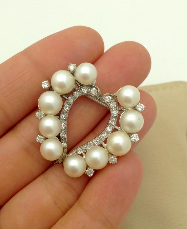 A woman holding Vintage 6mm South Sea Pearl 14k White Gold Brooch w/ 0.78CT VS Diamond Halo
