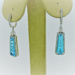 6.00 Ct Blue Topaz with 0.98 Ct Diamond Halo 14k Short Drop Earrings hanging on fake ears