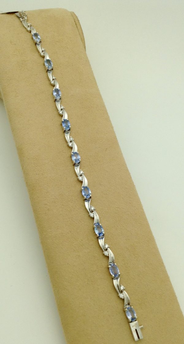 8.25 Ct Tanzanite and 0.16 Ct Diamond Swirl Bracelet 14k on a piece of carton