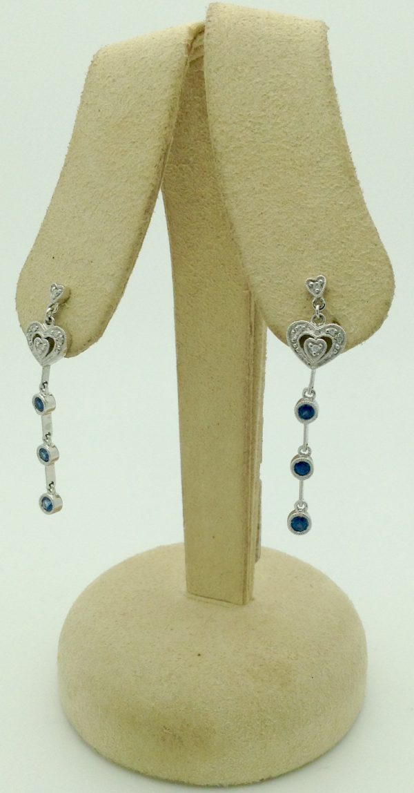0.65 carat Sapphire with 0.12 carat Diamonds Drop Earrings with 18K gold hanging on carton ears