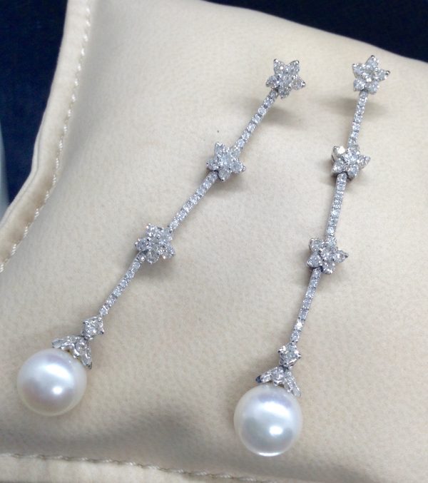 Two 18k White Gold Long Drop 1.50 Ct Diamond Earrings with 8mm South Sea Pearl Drops on a pillow