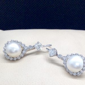 14k White Gold and 1.00 Ct Diamond Halo surrounding 6mm Mabe Pearls Short Drop on a pillow