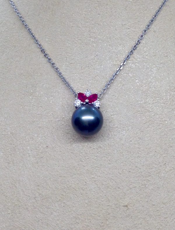 A woman wearing a 11mm Tahitian Pearl with 0.12 Ct Diamond and 0.20Ct Ruby 14k White Gold Pendant