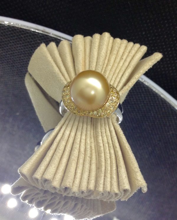 Flamboyant 12mm Golden South Sea Pearl with 0.74 Ct Canary Diamonds 18k White Gold Ring on a piece of glass (side view)