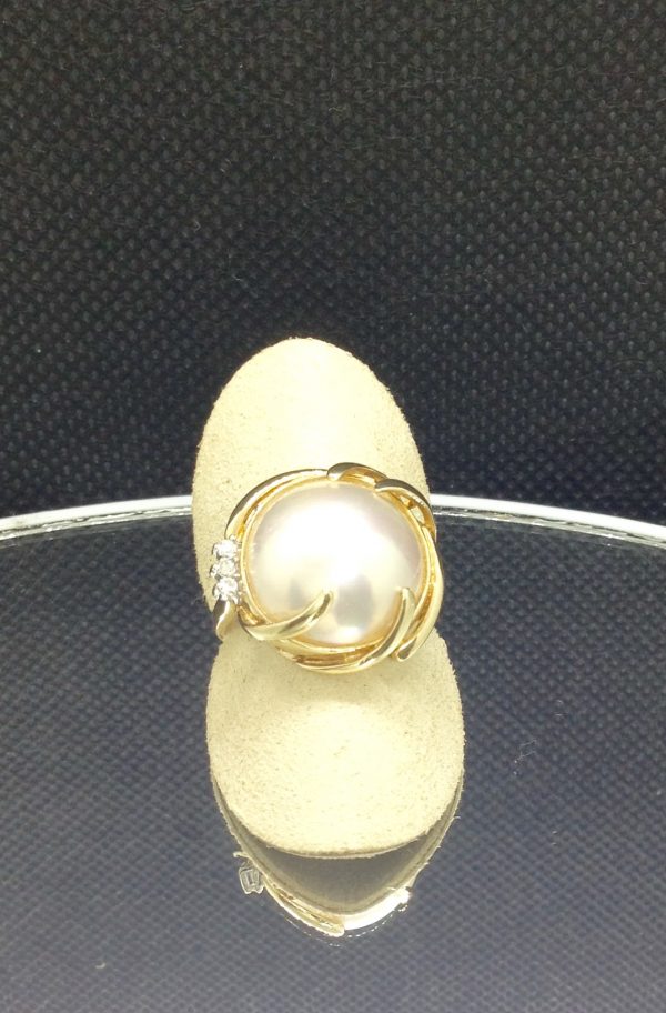 Alluring 13mm Mabe Pearl with 0.03 Ct Diamond Accents 14k Yellow Gold Ring on a piece of glass (top view)
