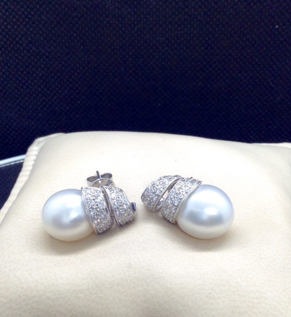 14mm South Sea Pearl 18k White Gold Earring with 1.25 Ct Diamond with a Twirling Design on a pillow