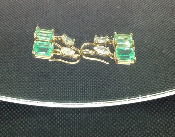 Four pieces of 5.00 Ct Colombian Emerald with 0.50 Ct Diamonds 14k Yellow Gold Short Drop Earrings on a piece of glass
