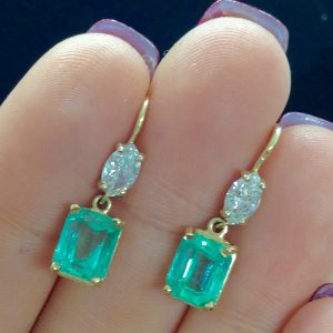 A woman holding 5.00 Ct Colombian Emerald with 0.50 Ct Diamonds 14k Yellow Gold Short Drop Earrings