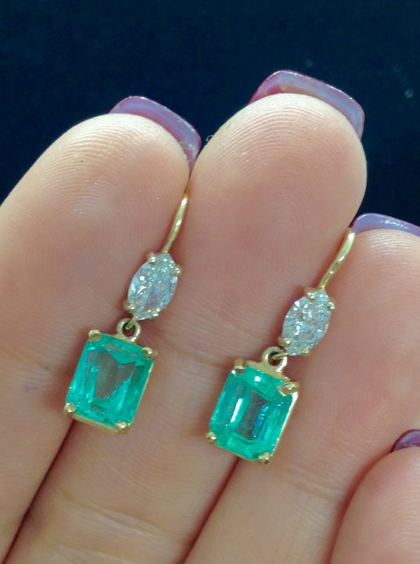 A woman holding 5.00 Ct Colombian Emerald with 0.50 Ct Diamonds 14k Yellow Gold Short Drop Earrings