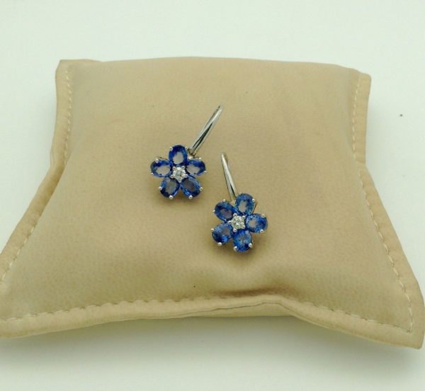 18K White Gold 6 CT Unheated Sapphire Flower Earrings W/ 0.60 CT VS Diamond hanging on a pillow