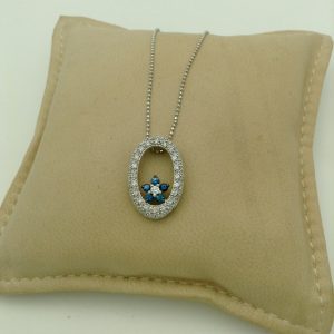 14k white gold diamond and sapphire necklace on a pillow