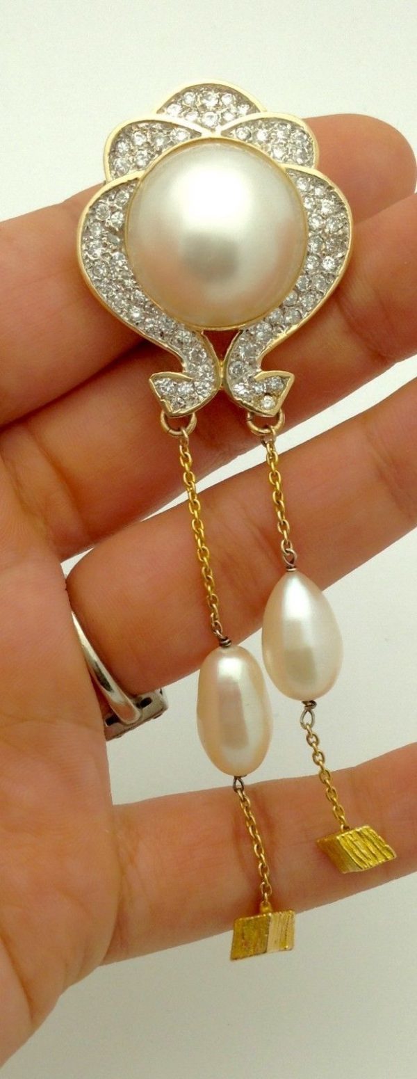 A woman holding a Vintage Hanging Brooch 14K Yellow Gold & 1CT VS Diamonds w/ South Sea Pearl