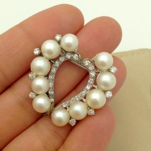 A woman holding Vintage 6mm South Sea Pearl 14k White Gold Brooch w/ 0.78CT VS Diamond Halo