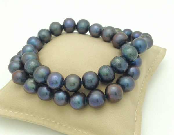 Elegant 12mm Black Tahitian Pearls w/ 14k White Gold Clasp on a pillow