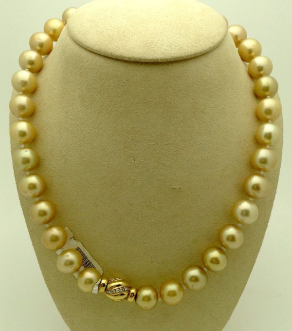 A side view of golden South Sea Pearls 16mm 18k Yellow gold Clasp w/ VS Diamonds accents on a fake neck