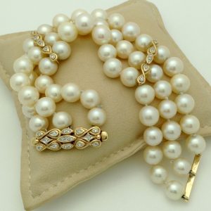3 Row South Sea Cultured Pearls 8mm 18k Yellow Gold Clasp w/ VS Diamonds accents on a pillow