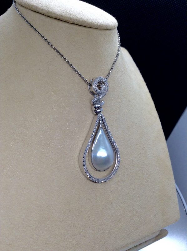 Side view of 18.7 Ct Mabe Pearl with 1.00 Ct Diamond 14k White Gold Pendant with 16" 14k White Gold Chain hanging on a fake neck