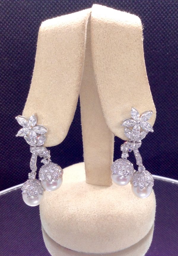 Front view of 7.34 Ct Diamonds with 10mm South Sea Pearls Medium Dangle Platinum Earrings hanging on fake ears