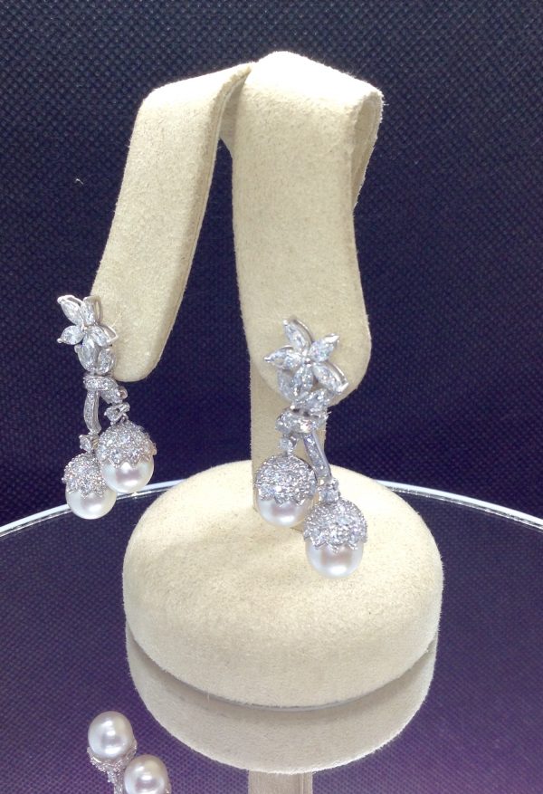 Side view of 7.34 Ct Diamonds with 10mm South Sea Pearls Medium Dangle Platinum Earrings hanging on fake ears