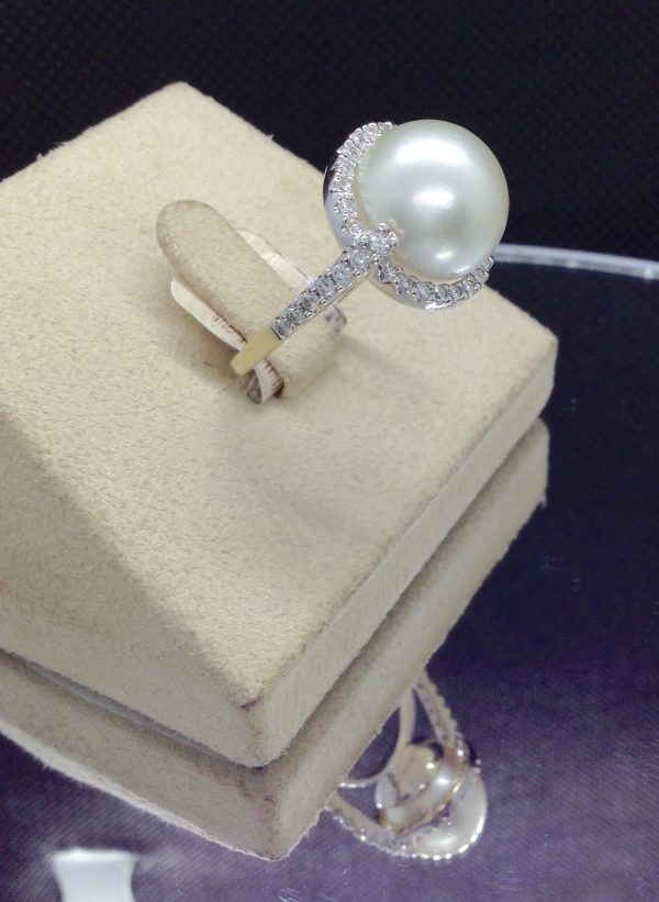 Side view of an Elegant 11mm South Sea Pearlwith 0.75 Ct Diamond 18k White Gold Cathedral Ring on a jewelry box