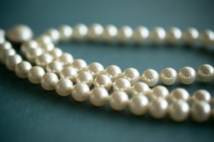 Several pearls tied to each other on top of a green surface